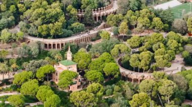 Park Guell 'in hava aracı görüntüsü. Antoni Gaudi mimarisi. Etrafta bir sürü yeşillik, turistler, Barselona, İspanya