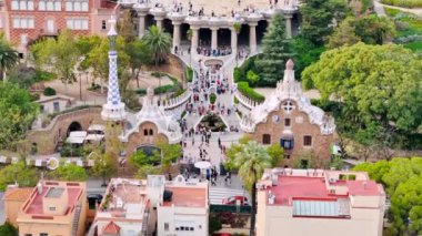 Park Guell 'in hava aracı görüntüsü. Antoni Gaudi mimarisi. Etrafta bir sürü yeşillik, turistler, Barselona, İspanya