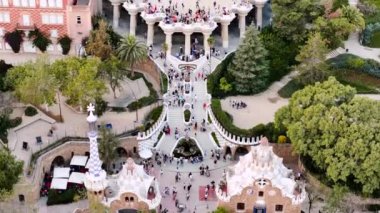 Park Guell 'in hava aracı görüntüsü. Antoni Gaudi mimarisi. Etrafta bir sürü yeşillik, turistler, Barselona, İspanya