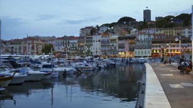 Cannes, Fransa - 26 Eylül 2023: günbatımında birden fazla demirli yatla deniz limanının görüntüsü. Castre Müzesi 'nin bulunduğu şehir manzarası, aydınlanma.