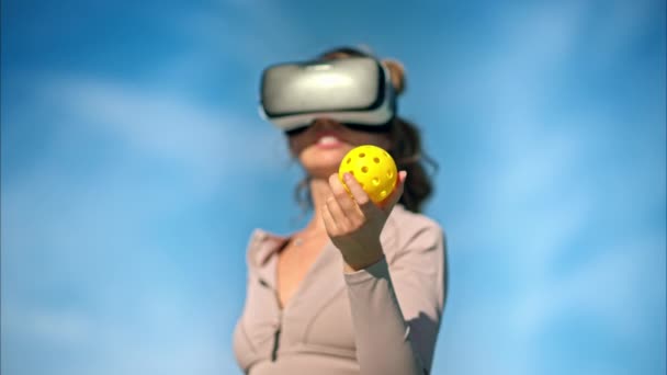 Mujer Con Realidad Virtual Auriculares Celebración Bola Pickleball Cielo Azul — Vídeo de stock