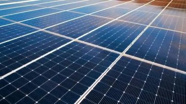 Yüksek verimli bir enerji fabrikasının çatısına kurulmuş mavi güneş panellerinin hava aracı görüntüsü