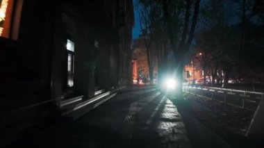 Geceleri mavi gökyüzü ve Chisinau, Moldova 'da yürüyen insanlarla araba ışıkları.