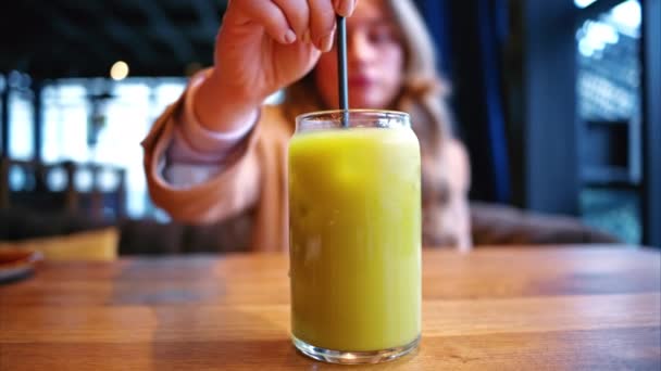 Mujer Revolviendo Cóctel Matcha Hielo Con Jugo Naranja Restaurante — Vídeo de stock