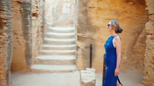 位于塞浦路斯帕福斯的国王墓考古遗址附近 身穿蓝色衣服的妇女走在那里 — 图库视频影像