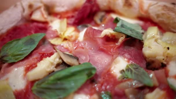 プロシュート アーティチョーク チーズ バジルとイタリアンレストランのプレート上のカプリシオサピザの近いビュー — ストック動画