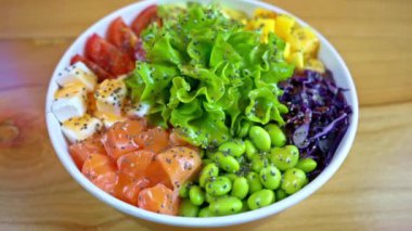 Somon balığı, avokado, feta peyniri, mango, domates, salata ve yeşil edamame fasulyesiyle yakın çekim yap.