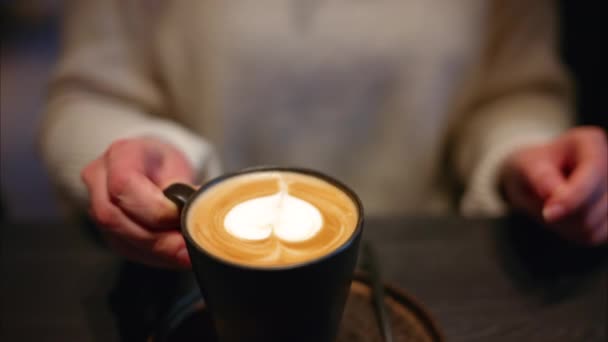 Kobieta Pijąca Cappuccino Sercem Ciemnobrązowego Kubka Kawiarni — Wideo stockowe