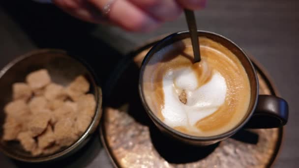 女人把红糖搅拌成一杯卡布奇诺白心咖啡 — 图库视频影像