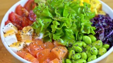 Somon balığı, avokado, feta peyniri, mango, domates, salata ve yeşil edamame fasulyesiyle yakın çekim yap.
