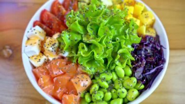 Somon balığı, avokado, feta peyniri, mango, domates, salata ve yeşil edamame fasulyesiyle yakın çekim yap.