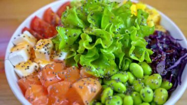 Somon balığı, avokado, feta peyniri, mango, domates, salata ve yeşil edamame fasulyesiyle yakın çekim yap.