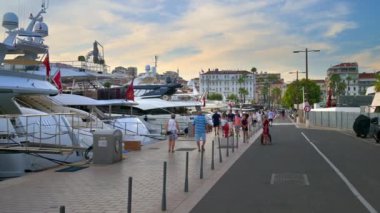 CANNES, FRANCE - 5 Eylül 2023 Yat yakınlarındaki iskelede yürüyen insanlar
