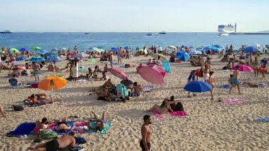 CANNES, FRANCE - 5 Eylül 2023: Güneşli bir günde insan ve şemsiyelerle dolu Croisette plajı