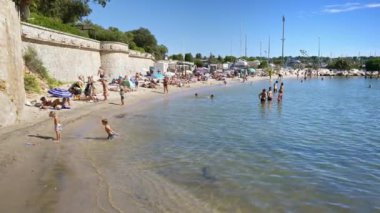 JUAN LES PINS, FRANCE - 4 Eylül 2023: Güneşli bir günde Port Galice plajında eğlenen insanlar