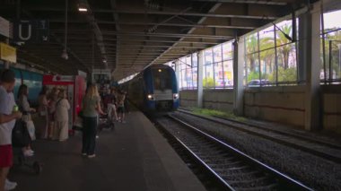 ANTIBES, FRANCE - 5 Eylül 2023: tren istasyonunda tren bekleyen insanlar. Yavaş çekim