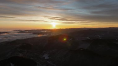 Dağlarda güneşin doğuşunu gösteren hava aracı görüntüsü. Ceahlau Ulusal Parkı, Romanya