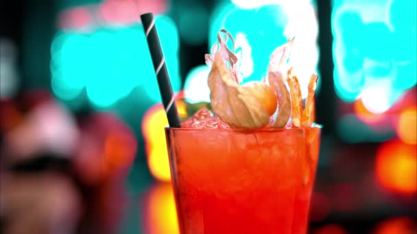 晚上在有霓虹灯的酒吧里 用冰块把橙红色的酒精鸡尾酒包起来 — 图库视频影像
