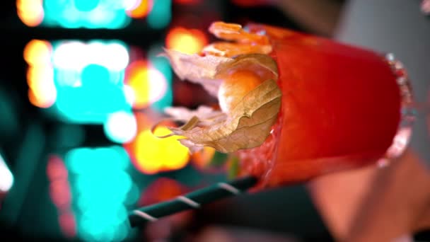 Zamknij Pomarańczowy Czerwony Koktajl Alkoholowy Lodem Barze Neonami Nocy — Wideo stockowe
