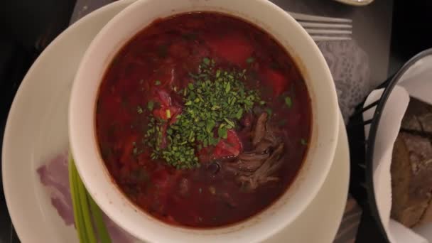 レストランで赤いウクライナのスープとホワイトサワークリームのゆっくり動き回転 — ストック動画