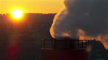 Güneş batarken arka planda olan termik santralin hava aracı görüntüsü. Tele-hoto orta çekim