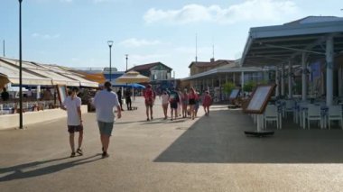 Paphos, Kıbrıs - 02 Ağustos 2023: Restoranlar, kafeler, barlar ve dükkanlarla dolu kıyı caddesinde gezinti