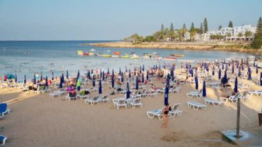 Protaras, Kıbrıs - 4 Ağustos 2023: İnsanlar İncir Ağacı Koyu plajında güneşleniyor