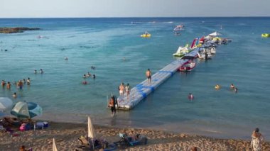 Protaras, Kıbrıs - 04 Ağustos 2023: İnsanlar Fig Tree Körfezi plajında yüzüyor ve güneşleniyor