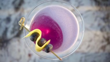 Üzerinde yaban mersini olan kırmızı bir martini.