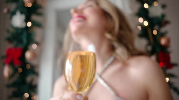 大晦日のパーティーの準備をする夜のドレスの女性 白いスパークリングワインのグラスを飲む — ストック動画