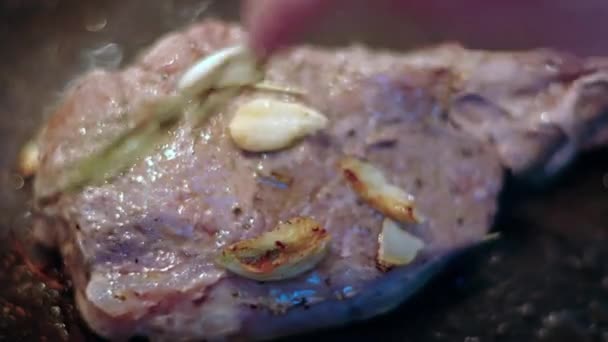 ローズマリーとニンニクで調理されているジューシーなリブエステのステーキ肉牛 — ストック動画