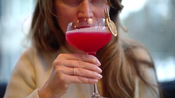 Mujer Bebiendo Bebida Roja Cóctel Con Naranja Seca Como Decoración — Vídeos de Stock
