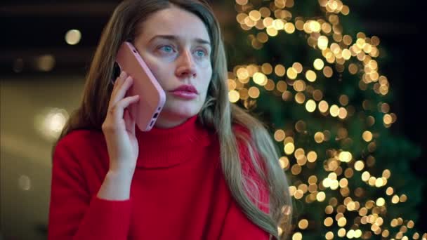 Kvinna Röd Tröja Talar Smartphone Med Julgran Bakgrunden — Stockvideo