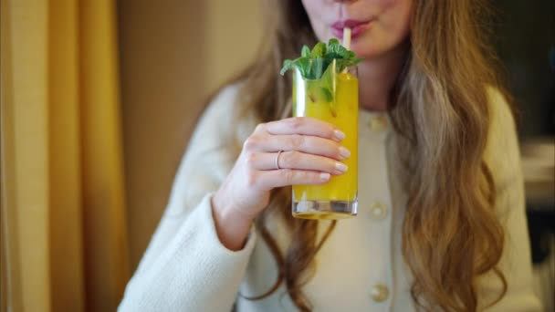 Kobieta Pijąca Świeżą Pomarańczową Lemoniadę Liśćmi Mięty Papierową Słomką — Wideo stockowe