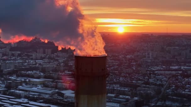 日没のシナウで働く熱力発電所の空中ドローンビュー 雪に覆われた街 パイプからの蒸気と煙 モルドバ — ストック動画