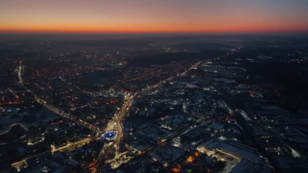 雪に覆われたシナウ市の空中ドローンビューは 日没時に交通を移動します モルドバの冬 — ストック動画
