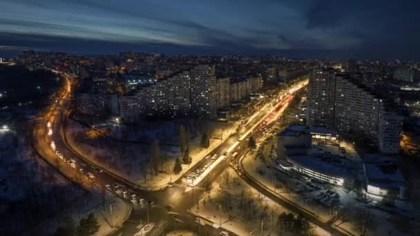 シティゲートの空中無人機の重複のタイムラプス 複数の建物と夜に移動する交通 青い時間 モルドバのシナウの冬 — ストック動画