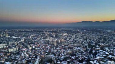 Plovdiv şehrinin güneş batarken karla kaplı panoramik hava aracı görüntüsü. Bulgaristan