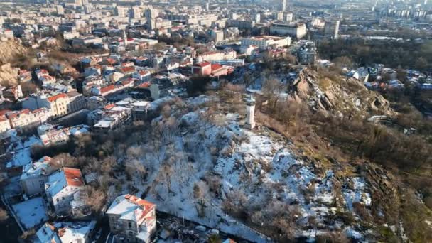 从空中俯瞰萨哈特泰佩顶部的钟楼 保加利亚普罗夫迪夫被雪覆盖的时钟山 — 图库视频影像
