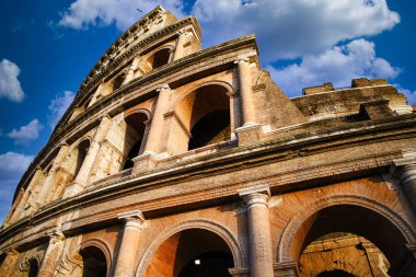 Parlak mavi gökyüzü ve bulutları olan Roma Kolezyumu. Roma, İtalya