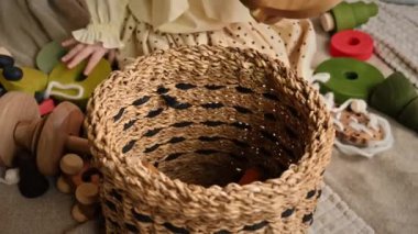 Küçük kızın elleri sepetin içine tahta oyuncaklar koydu. Ekolojik ve sürdürülebilirlik kavramı