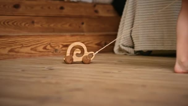 小女孩在地板上玩一个木制蜗牛滚动玩具 生态和可持续性概念 — 图库视频影像