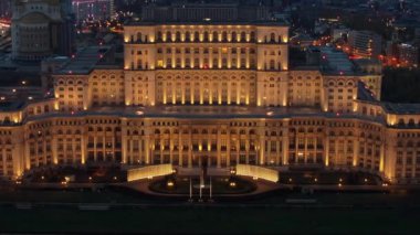 Akşam Bükreş 'teki Parlamento Sarayı' nın aydınlanmış hava aracı görüntüsü. Çevrede çok sayıda bölge var. Romanya