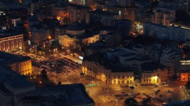 Carol I Üniversitesi Vakfı 'nın gece hava aracı görüntüsü. Carol 'ın olduğu ana bina önünde heykeller, yollar ve binalar. Bükreş kenti ve Romanya aydınlandı