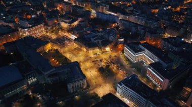 Carol I Üniversitesi Vakfı 'nın gece hava aracı görüntüsü. Carol 'ın olduğu ana bina önünde heykeller, yollar ve binalar. Bükreş kenti ve Romanya aydınlandı