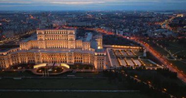 Akşam Bükreş 'teki Parlamento Sarayı' nın aydınlanmış hava aracı görüntüsü. Çevrede çok sayıda bölge var. Romanya