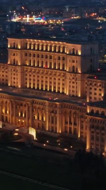 Bükreş 'teki Parlamento Sarayı' nın akşam saatlerinde aydınlanan hava aracı görüntüsü. Çevrede çok sayıda bölge var. Romanya