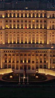 Bükreş 'teki Parlamento Sarayı' nın akşam saatlerinde aydınlanan hava aracı görüntüsü. Çevrede çok sayıda bölge var. Romanya