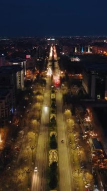 Gece aydınlanan şehir manzarasının dikey hava aracı görüntüsü. Romanya 'nın Bükreş kentinde trafiğin ilerletilmesi
