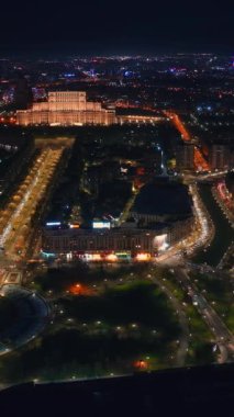 Şehir merkezindeki Parlamento Sarayı 'nın aydınlatılmış halinin dikey hava aracı görüntüsü. Romanya 'nın Bükreş kentinde çok sayıda bölge